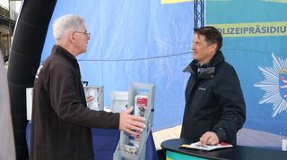 Michael Fix (r.) aus dem Polizeipräsidium Südhessen im Beratungsgespräch mit einem Bürger zum Thema Einbruchsschutz.