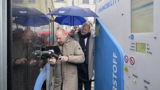 Frank Fronzke (l.) von H MOBILITY zeigt RNV-Aufsichtsratschef Christian Specht und anderen Ehrengästen, wie ein Linienbus mit Wasserstoff betankt wird.