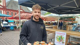 Marcel Höhn verkauft auf dem Mannheimer Mittagsmarkt pfälzische Brotspezialitäten.