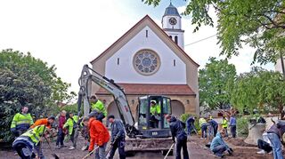 Mit Schaufeln, Spaten und Kleinbagger machen die Jugendlichen ehrenamtlich aus der Fläche vor der Christ-König-Kirche einen Platz der Begegnung.