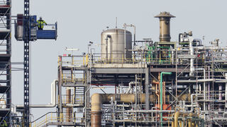 Ein Arbeiter fährt neben Gebäuden auf dem Werksgelände des Chemiekonzerns BASF in Ludwigshafen in einem Aufzug.