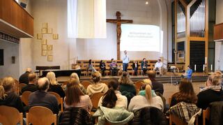 In der Johanniskirche auf dem Lindenhof moderierte Elternbeirat Dominik Bonaszewski (Mitte, stehend) die Podiumsdiskussion zum Thema Kitas.