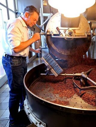 Jörg Bischof an der gusseisernen Röstmaschine.