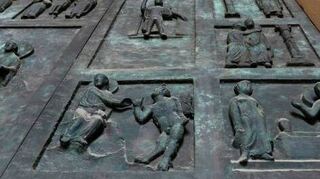 Das bronzene Domhauptportal trägt viele biblische Szenen.