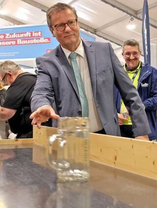 Klappt erst nach Wartezeit: Minister Hauk beim Bierkrugschieben.