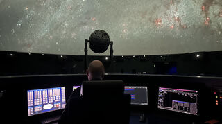 Mathias Jäger steuert hinter dem Vorführerpult die Technik im Mannheimer Planetarium. In der Mitte des Raumes steht der Sternenprojektor.