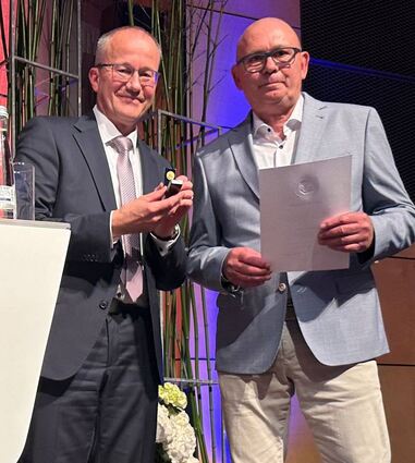 Vorstandssprecher Till Meßmer ehrt den langjährigen Aufsichtsrat Michael Hammann.