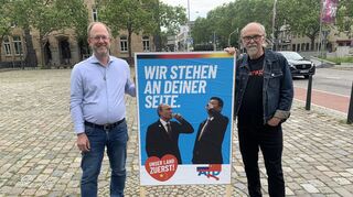 Chris Rihm (l.) und Gerhard Fontagnier zeigen in D 5 ihr Plakat.