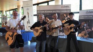 Joe Striebel (v.l.), Joachim Sum, Andreas Cuntz und Mitarbeiter Jakob Reiss stellen Gitarren vor, die in der Ausstellung gezeigt wurden.