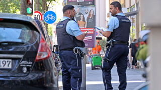 Yakub Butt und Akram Kronauer kontrollieren in der Kunststraße Wahlplakate, die unzulässigerweise auf der rechten Seite in Fahrtrichtung hängen.