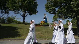 Was ist eine Verehrung wert – und was nicht? Sorbische Mädchen tragen eine Marienstatue zum Pfingstgottesdienst (Aufnahme vom 29. Mai 2023).