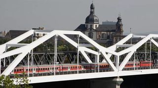 Prägende Bauten: Oben die SAP Arena beim ersten Lichttest, unten links die für die neue S-Bahn erbaute zusätzliche Bahnbrücke neben der Konrad-Adenauer-Brücke mit der Jesuitenkirche im Hintergrund und rechts das im Mittelbau aufgestockte Schloss mit neuem Ehrenhof.