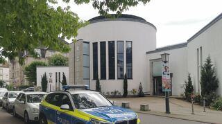 Ein Polizeiwagen steht vor der Neuen Synagoge. Weil er einen tödlichen Anschlag auf Besucher der Synagoge geplant haben soll, ist ein 18-Jähriger aus Weinheim verhaftet worden. Er soll sich mit einem 24 Jahre alten Mann, der ebenfalls bereits in U-Haft ist, im Netz über einen Messerangriff auf Besucher der Synagoge ausgetauscht haben. Foto: Dieter Leder/dpa +++ dpa-Bildfunk +++