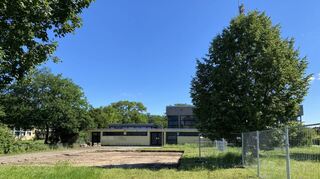 Vor der Sporthalle sollen übergangsweise Container als Klassenräume dienen, jetzt wird der Boden dafür bereitet.