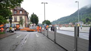 Im Bereich des Neckarmünzplatzes werden vorsorglich Spundwände am Neckar aufgebaut und ein Lkw voller Sandsäcke steht bereit.