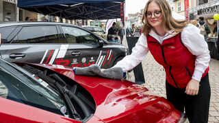 Lara muss wegen des immer wieder einsetzenden Regens die Autos, wie diesen MG am Stand des Autohauses Raber, zwar immer wieder trockenpolieren, lässt sich aber die gute Laune nicht verderben.