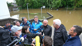 Winfried Kretschmann (Grüne, 2.v,r), Ministerpräsident von Baden-Württemberg, und Landesinnenminister Thomas Strobl (CDU, 3.v.r) stellen sich nach einer Besichtigung der Hochwasserschäden in Meckenbeuren den Fragen der Journalisten.