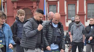 Mannheim trauert: Zahlreiche Personen, darunter auch Polizisten, stehen in unmittelbarer Nähe des Tatorts auf dem Mannheimer Marktplatz vor niedergelegten Kerzen und Blumen.