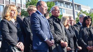 Christian Specht mit Partnerin Bettina Schenk (1. Reihe v.l.), Thomas Strobl, Nancy Faeser und Muhterem Aras halten nach dem Blumen-Niederlegen inne.