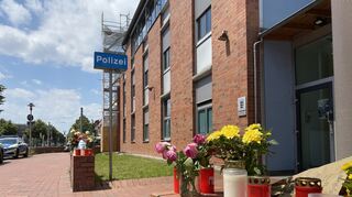 Blumen, Kerzen und ein Bild von Laur vor der Wache in Neckarau.