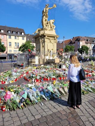 Auf dem Mannheimer Marktplatz werden Blumen und Kerzen für den getöteten Polizisten Rouven Laur abgelegt. Eine öffentliche Trauerfeier soll im Rosengarten stattfinden.