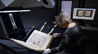Bettina Dreis richtet ein Chorbuch aus dem Mittelalter unter einem Spezialscanner aus, um das Buch zu digitalisieren.