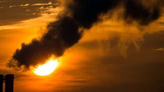 Die Morgensonne hinter qualmenden Schornsteinen eines Blockheizkraftwerks: Wer Abgase ausstößt, muss zahlen.