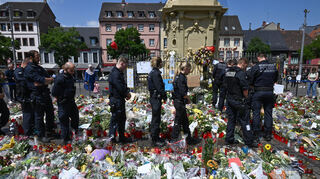 Mannheim: Polizisten stehen auf dem Marktplatz vor einem Gedenkplatz für einen bei einer Messerattacke getöteten Polizisten.