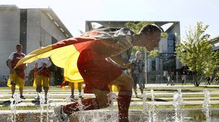 Abkühlung nötig: Ein Deutschland-Fan erfrischt sich in einer kleinen Fontäne auf dem Fanfest vor dem Bundeskanzleramt in Berlin bei der WM 2006.