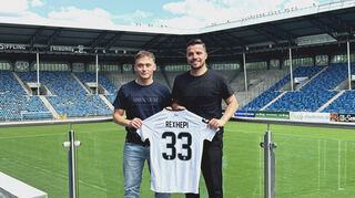 Arlind Rexhepi (links) unterzeichnet seinen Vertrag beim SV Waldhof 07 neben Anthony Loviso (rechts), Technischer Leiter Sport des SV Waldhof Mannheim 07.