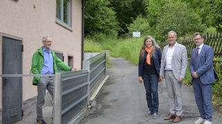 Egon Müller aus Ziegelhausen zeigt (v.l.) Sabine Lachenicht, Eckart Würzner und Raoul Schmidt-Lamontain die Metallwand, die sein Haus schützt.