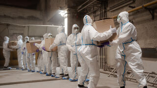 Polizisten in Schutzanzügen verladen sichergestelltes Kokain.