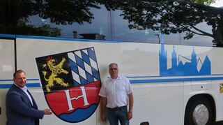 Bürgermeister Achim Weitz (l.) und Bus-Unternehmer Holger Schmidt vor dem neuen Heddesheim-Fahrzeug mit Wappen und Silhouette der Gemeinde.
