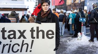 Marlene Engelhorn während einer Kundgebung im Januar 2024 in Davos vor dem Weltwirtschaftsformum. Sie hält ein Plakat mit der Aufschrift "Besteuert die Reichen!".