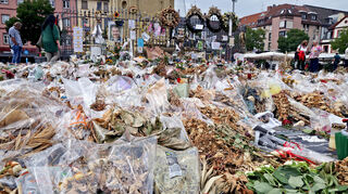 Drei Wochen nach dem tödlichen Messerangriff in Mannheim liegen noch verwelkte Blumen beim Tatort am Marktplatz.