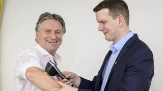 Minister Manne Lucha (l.) erkundigt sich im DKFZ bei Titus Brinker über die KI-gestützte Hautkrebsdiagnostik – und krempelt dabei die Ärmel hoch.