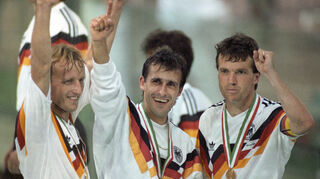 Pierre Littbarski (Mitte) mit Andreas Brehme (l.) und Lothar Matthäus (r.) jubeln nach dem Finalsieg gegen Argentinien bei der Fußball-Weltmeisterschaft im Olympiastadion.