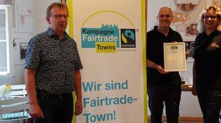 Matthias Baaß (v.l.), Robert Toth und Sonja Ott mit der Urkunde zur erneuten Auszeichnung von Viernheim als Fairtrade-Stadt.