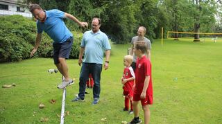 Bürgermeister Volker Proffen (l.) auf der neuen Slackline, beobachtet von Vereinschef Christoph Hambusch (2. v. l.) und TSV-Jugendtrainer Andreas Landmann.