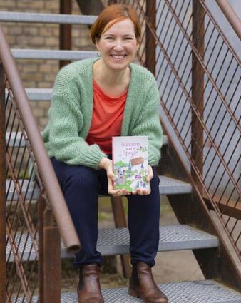 Katja Edelmann mit ihrem Buch über Glücksorte in Speyer.