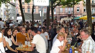 Beim geselligen Hock ist der gemütliche Biergarten unter Bäumen prall gefüllt.
