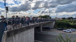 Zu Fuß über den Stau: Fans überqueren die B 39 bei der Abfahrt Mitte in Höhe des McDonald’s-Restaurants scharenweise vom Parkplatz P 8 beim DRK.