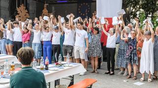 Beim Partnerschaftsabend auf dem Dorfplatz lassen sich die Chöre aus beiden Gemeinden für ihre musikalische Darbietung feiern.