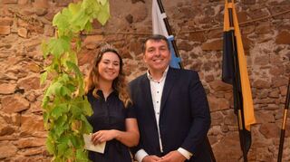 Beim Empfang für die neue Badische Weinprinzessin überreicht Bürgermeister Christoph Oeldorf eine Weinrebe an Sofia Hartmann.