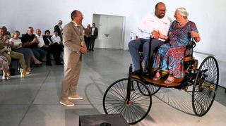 Oberbürgermeister Christian Specht empfängt Preisträger Frank Röske und Jutta Benz, die auf einem Benz-Patent-Motorwagen in die Halle fahren.
