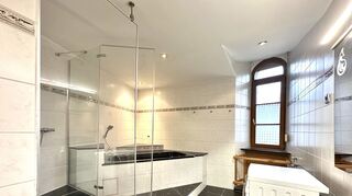 Das Badezimmer ist eng geschnitten, verfügt aber über Eckbadewanne und separate Dusche.
