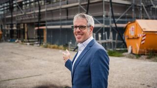 Außenansicht: Landrat Christian Engelhardt zeigt auf das neue Schulgebäude, das in den nächsten Sommerferien bezogen werden soll.