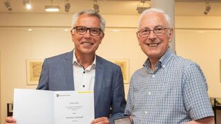 Landrat Stefan Dallinger (l.) überreicht Herbert Kempf die silberne Ehrenmedaille des Rhein-Neckar-Kreises.