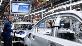 Mitarbeiter von BMW arbeiten im Stammwerk München in der Produktion an der Karosserie von Autos.