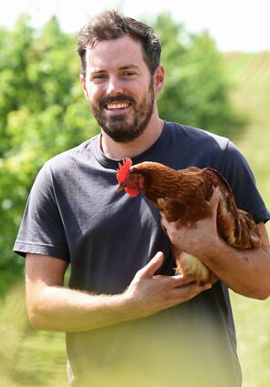 Der neue UBL-Gemeinderat Dennis Koch mit einem seiner Hühner auf dem Hof in Edingen.